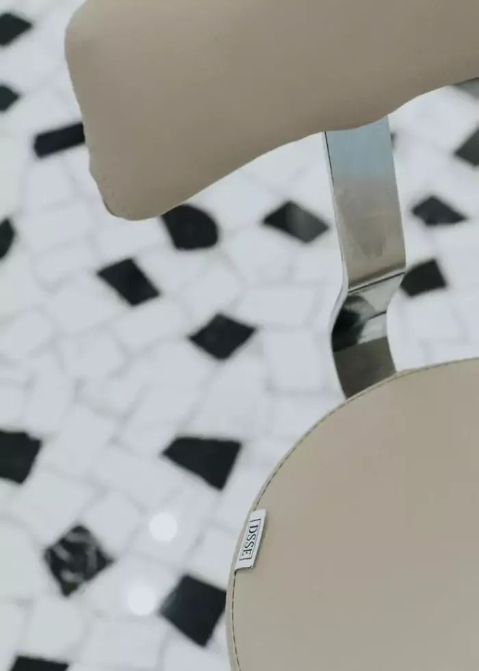 Close-up of salon chair base on tiled floor